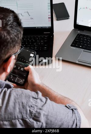 Junger bärtiger Mann zu Hause, der an einem Laptop arbeitet Stockfoto