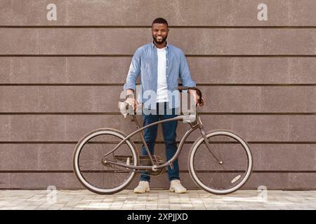 Lange Porträt eines glücklichen afroamerikanischen Mannes mit Fahrrad Stockfoto