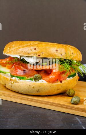 Hausgemachte und geräucherte Lachsbagel, mit Frischkäse, Kapern, Gurke und Dill, Porträt. Stockfoto