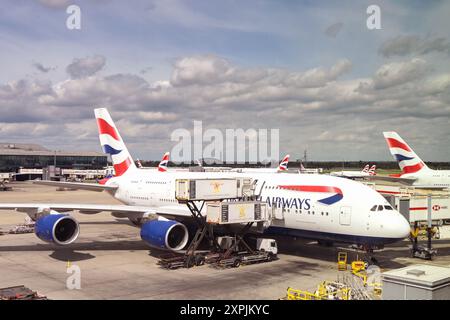 London, England, UK - 4. Mai 2024: Verladung von Catering-Versorgungsmaterial in einen British Airways Airbus A380 mit einem Scherenlift Stockfoto