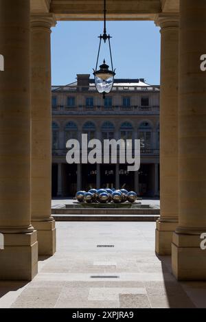 Paris, Frankreich 08.05.2024 Blick auf den Brunnen von Pol Bury durch die Säulen des Palais Royal Stockfoto