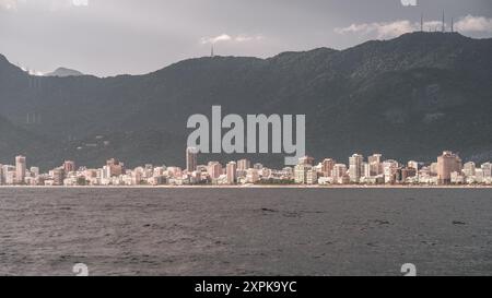 Panoramablick auf den Strand von Ipanema in Rio und die umliegenden Hochhäuser, die vom Wasser erfasst werden. Die Szene zeigt den Kontrast zwischen dem b Stockfoto