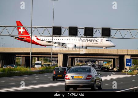 Flughafen Amsterdam Schiphol, Helvetic Airways Embraer ERJ-195, Flieger auf dem Rollweg, Brücke über die Autobahn A4, Verbindung von der Polderbaan Runway zum Terminal, Niederlande, Amsterdam Schiphol *** Amsterdam Schiphol Airport, Helvetic Airways Embraer ERJ 195, Flugzeug auf dem Rollweg, Brücke über die Autobahn A4, Verbindung von der Start- und Landebahn Polderbaan zum Terminal, Niederlande, Amsterdam Schiphol Stockfoto