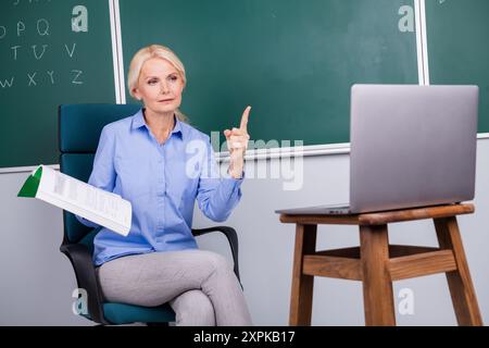 Foto einer qualifizierten selbstbewussten Frau Schullehrerin erzählen Informationsstunde erklären Materialien College Schule Stockfoto