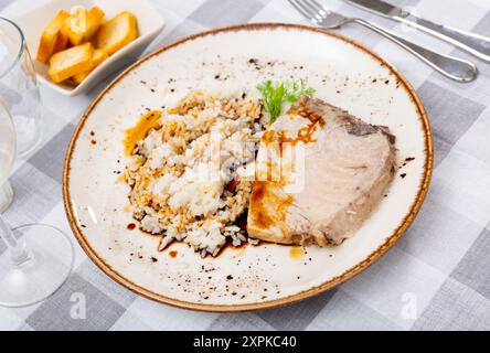 Köstliches gegrilltes Thunfischsteak mit weißem Reis und Sojasoße, serviert auf einem Teller mit Besteck und Brot Stockfoto