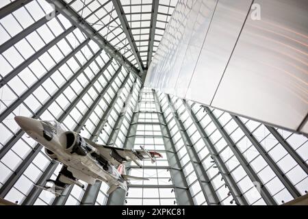 AV-8B Harrier Jump Jet National Museum Of The Marine Corps Triangle Virginia | TRIANGLE, Virginia, Vereinigte Staaten — Eine AV-8B Harrier „Jump Jet“ hängt unter dem kegelförmigen Glasdach der Leatherneck-Galerie im National Museum Of The Marine Corps, ihr geneigter Mast ist über ihr sichtbar. Die vertikale Start- und Landefähigkeit des Harrier machte ihn zu einer charakteristischen Ergänzung der Luftnahunterstützung des Marine Corps seit der Einführung des Flugzeugs in den 1980er Jahren. Das Stahl-und-Glas-Atrium der Galerie erhebt sich etwa 160 Fuß (49 m) über den Museumsboden. Stockfoto