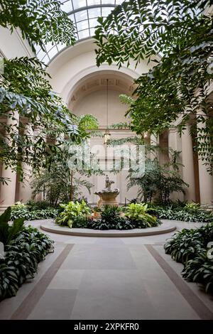 WASHINGTON DC, USA – der East Garden Court in der National Gallery of Art in Washington DC. dieser neoklassizistische Innenhof wurde vom Architekten John Russell Pope entworfen. er verfügt über einen zentralen Brunnen, Marmorsäulen und ein großes Oberlicht und bietet Besuchern einen ruhigen Raum, um Skulpturen und Grünflächen im Museum zu genießen. Stockfoto