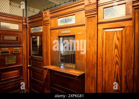 WASHINGTON DC, USA – Ein klassischer US-Postschalter, der im Smithsonian National Postal Museum in Washington DC ausgestellt wird. Dieses gut erhaltene Artefakt bietet Besuchern einen Einblick in den täglichen Betrieb und den Kundenservice historischer Postämter. Darstellung verschiedener Elemente des Postverkehrs und der Postverarbeitung aus dem späten 19. oder frühen 20. Jahrhundert. Stockfoto