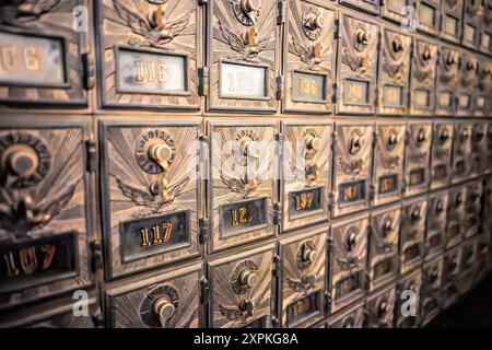 Vintage Post Office Boxen National Postal Museum Washington DC | WASHINGTON D.C., Vereinigte Staaten – Reihen von Messing Postbüroboxen mit Adlermotiven und Kombinationsschlössern im Smithsonian National Postal Museum. Diese kunstvoll verzierten Kisten, die einst in den US-Postämtern als Standard gelten, ermöglichten es den Kunden, Briefe abzuholen, ohne an einem Schalter zu warten, ein System, das sich im späten 19. Und frühen 20. Jahrhundert weit verbreitete. Stockfoto