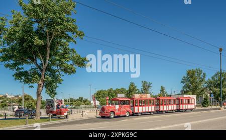 Roter Touristenzug auf der Santa Clara Brücke in der portugiesischen Stadt Coimbra, Portugal, Europelandscape Stockfoto