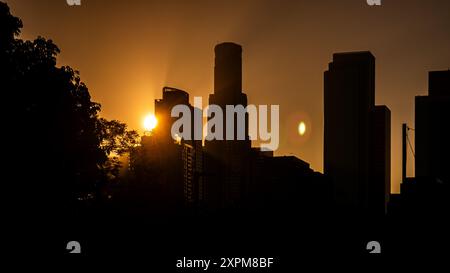 Sonnenuntergang hinter Wolkenkratzern, Skyline von Little Tokyo oder Skid Row, Los Angeles, Kalifornien, Licht strömt durch die Luftverschmutzung in der Stadt Stockfoto