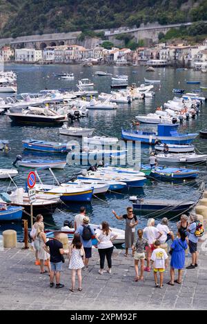 Scilla, Italien. August 2024. Leute, die im Hafen von Scilla gesehen wurden. Eine Zeremonie für den 1995 auf mysteriöse Weise verstorbenen Kapitän Natale de Grazia fand an Bord des italienischen Marineschiffs Palinuro in Scilla statt. Dank der Bemühungen von Magna Grecia Outdoor Association und Scillas Sektion des italienischen Seemannsverbandes wird der Hafen von Scilla de Grazia gewidmet sein. Quelle: SOPA Images Limited/Alamy Live News Stockfoto