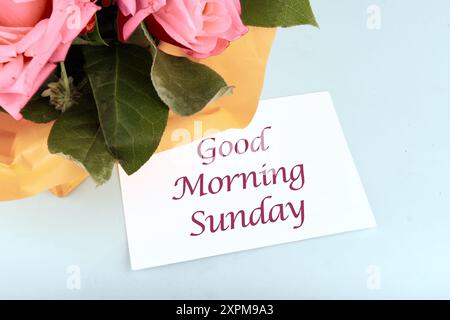 GUTEN MORGEN WELT die Inschrift auf der Visitenkarte in der Komposition mit Blumen Stockfoto