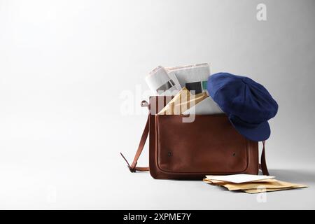 Braune Brieftasche, Briefumschläge, Zeitungen und Hut auf grauem Hintergrund. Leerzeichen für Text Stockfoto