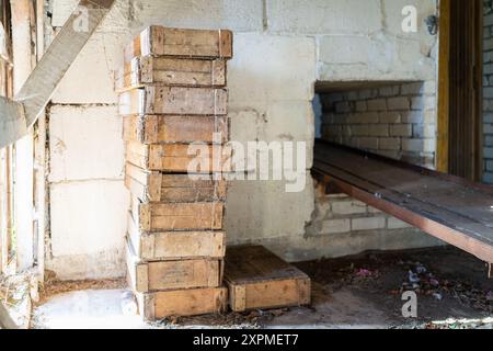 Hölzerne Fischkisten im Inneren eines verlassenen Fischfabrikgebäudes. Alte verlassene Fischfabrik im Inneren. Vintage Holzkisten für Fisch. Stockfoto