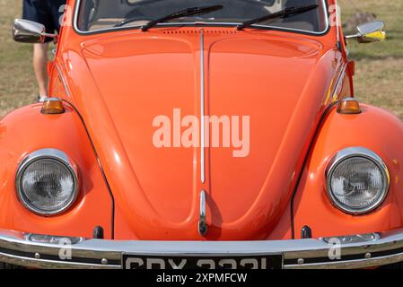 Vorderansicht eines ikonischen, leuchtend orangefarbenen Volkswagen Käfers. August 2024. Stockfoto