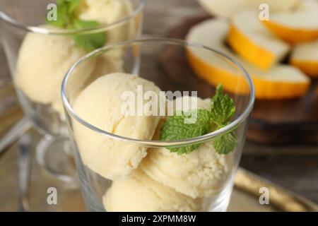 Löffel Melonensorbet und Minze in Dessertschalen aus Glas auf dem Tisch, Nahaufnahme Stockfoto