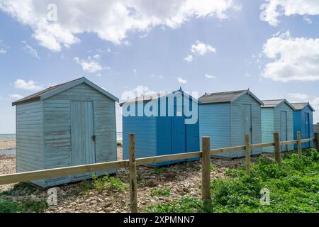 Fünf blaue Strandhütten in Folge am Charmouth Beach, Dorset Stockfoto