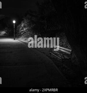 Cres, Kroatien - 8. April 2023: Weg am Meer in der Nacht, Straßenlaterne, schwarz-weiß, Parkbank Stockfoto