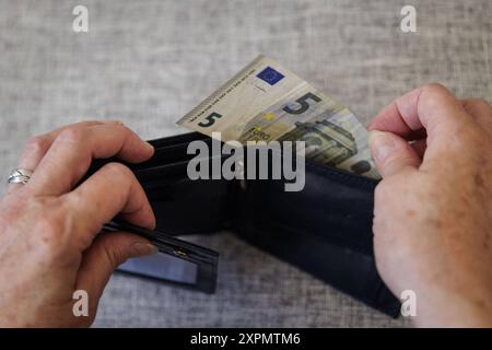 Eine aeltere Frau nimmt fuenf Euro aus ihrem Portemonnaie. Berlin, 05.08.2024. Berlin Deutschland *** eine ältere Frau nimmt fünf Euro aus der Tasche Berlin, 05 08 2024 Berlin Deutschland Copyright: XKiraxHofmann/photothek.dex Stockfoto