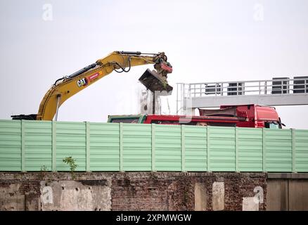 Bochum, Deutschland. August 2024. Ein Bagger arbeitet hinter einer Lärmschutzwand auf der abgesperrten Autobahn A40. Kurz nach Beginn der Straßensperrung am Dienstagabend erklärt die Niederlassung Westfalen der Autobahn GmbH das komplexe Projekt vor Ort. Die stark frequentierte Ruhrautobahn ist wegen des Baus einer neuen Brücke bis Anfang November gesperrt. Quelle: Bernd Thissen/dpa/Alamy Live News Stockfoto