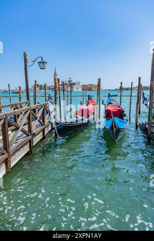 Venedig, Italien - 26. Juli 2024: Gondeln gegen die Insel San Giorgio in Venedig, Italien. Die Gondel ist der attraktivste Touristenverkehr in Venedig. T Stockfoto