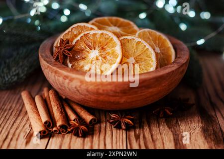 Weihnachtsdekoration mit getrockneten Orangenscheiben, Zimtstangen und Anis-Sternen in Holzschale. Weihnachten oder Neujahr Hintergrund Stockfoto