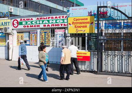 Almaty, Kasachstan, 17. April 2012. Geschäftige Straßenszene in Almaty mit Wechselstube und Fußgängern in Bewegung. Stockfoto