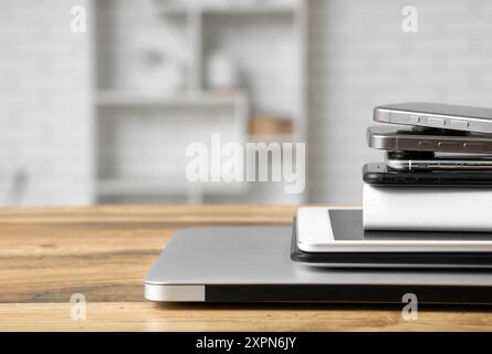 Stapel moderner Gadgets auf Holztisch in der Werkstatt Stockfoto