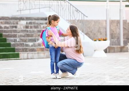 Mutter sagt Auf Wiedersehen zu ihrer kleinen Tochter in der Nähe der Schule Stockfoto