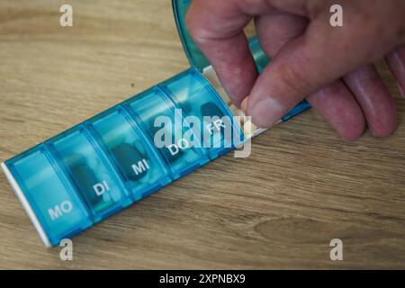 Ein Aelterer Mann nimmt Tabletten aus einer Tablettenbox. Berlin, 05.08.2024. Berlin Deutschland *** ein älterer Mann nimmt Pillen aus einer Pillenbox Berlin, 05 08 2024 Berlin Deutschland Copyright: XKiraxHofmann/photothek.dex Stockfoto