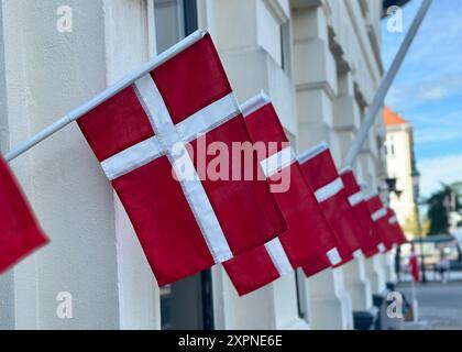 Kopenhagen, Dänemark. August 2024. Dänische Flaggen hängen von einem Geschäft in der Nähe von Nyhavn, dem beliebten Touristenhafen im Zentrum von Kopenhagen. Quelle: Steffen Trumpf/dpa/Alamy Live News Stockfoto