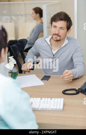 Arzt spricht mit männlichem Patienten zur Kniebehandlung Stockfoto