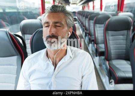 Glücklicher Mann, der im Reisebus schläft Stockfoto