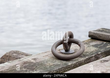 Festmacherring für Boote im Hafen, alter grauer Holzpier in der Ostsee, Finnland Stockfoto