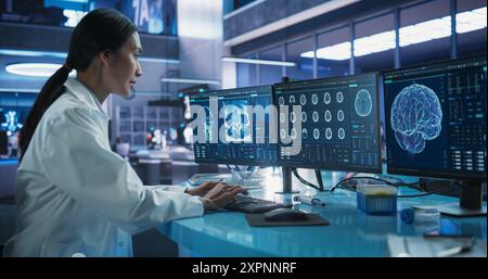 Krankenhausforschungslabor: Asiatische Wissenschaftlerin mit Computer mit Brain Scan MRT-Bildern. Professioneller Neurologe, der CT-Scan analysiert und die Behandlung von Patienten mit Hirnschäden findet. Stockfoto