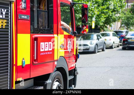 LONDON, JULI 2024: Ein LFB-Feuerwehrfahrzeug der Londoner Feuerwehr ist in Chelsea im Südwesten Londons unterwegs Stockfoto