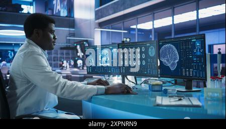 Schwarzer männlicher Neurowissenschaftler mit Desktop-Computer zur Analyse von MRT-Scans des Gehirns im Labor des medizinischen Forschungszentrums. Afrikanischer Arzt, der CT-Scan von Schlaganfallpatienten studiert, Lösungen findet. Stockfoto