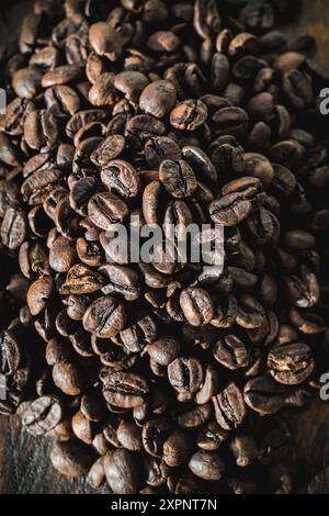 Eine Nahaufnahme eines großen Haufens reichhaltiger, gerösteter Kaffeebohnen, die ihre Textur und Farbe zeigen. Stockfoto