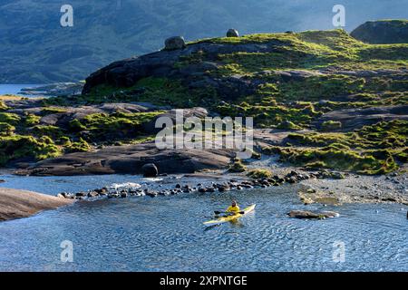 Ein Kajakfahrer auf Loch Coruisk in der Nähe der Trittsteine über dem Scavaig River. In den Cuillin Mountains, Isle of Skye, Schottland, Großbritannien. Stockfoto