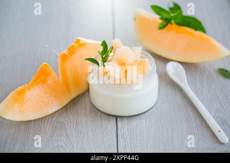 Süßer hausgemachter Joghurt im Glas mit reifem Melonenstück. Stockfoto