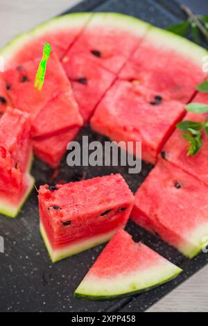 Stücke reifer roter Wassermelone, Nahaufnahme, auf einem Brett. Stockfoto