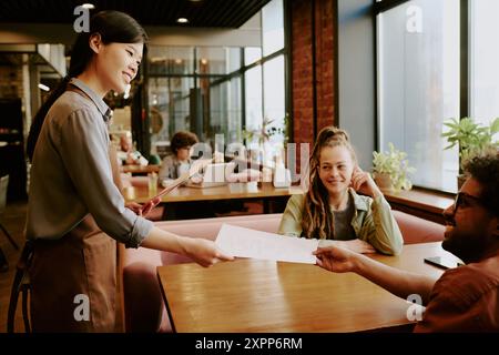 Gäste werden in einem modernen gemütlichen Café bedient Stockfoto