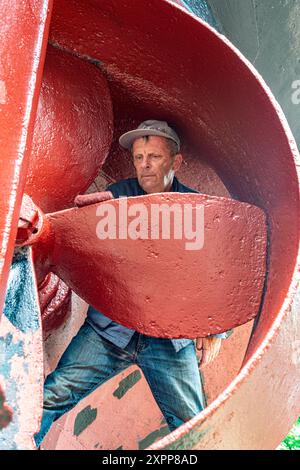 Crraftsman Painting Vessel Craftsman Painting the Hull and Propeller of a Historical Steam Thug on Koningspoort Historical Shipyard. Rotterdam, Niederlande. Rotterdam Oude Haven / Koningspoort Zuid-Holland Nederland Copyright: XGuidoxKoppesxPhotox Stockfoto