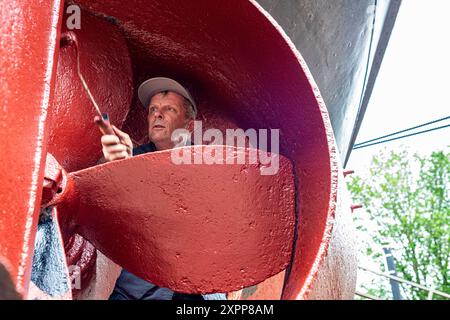 Crraftsman Painting Vessel Craftsman Painting the Hull and Propeller of a Historical Steam Thug on Koningspoort Historical Shipyard. Rotterdam, Niederlande. Rotterdam Oude Haven / Koningspoort Zuid-Holland Nederland Copyright: XGuidoxKoppesxPhotox Stockfoto