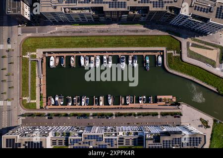 Blick von oben auf den Erholungshafen Noorderhaven mit zeitgenössischen, modernen Außenfassaden von Apartmenthäusern auf beiden Seiten und ein paar Booten Stockfoto