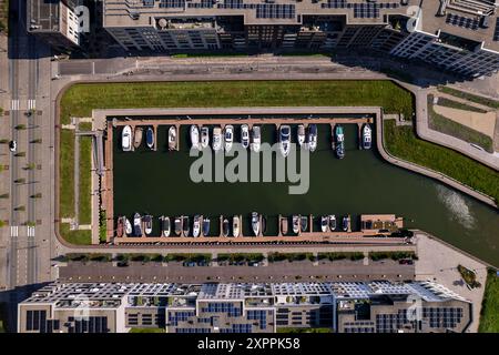 Blick von oben auf den Erholungshafen Noorderhaven mit zeitgenössischen, modernen Außenfassaden von Apartmenthäusern auf beiden Seiten und ein paar Booten Stockfoto