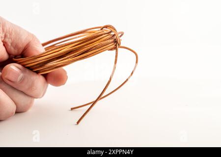 Person Frau mit Rolle aus natürlichem gegerbtem Leder, in feine Streifen geschnitten für Schnürbänder Armbänder und Bastelarbeiten Stockfoto