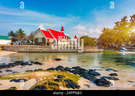 Rote Kirche im Dorf Cap Malheureux auf Mauritius. Notre Dame de Auxiliatrice, ländliche Kirche mit rotem Dach im tropischen Dorf Cap Malheureux auf M Stockfoto