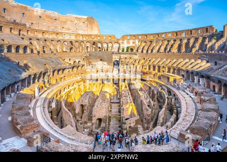 Ein Blick auf das Kolosseum in Rom bei Sonnenuntergang und Blick hinunter in die Arena. Das antike Amphitheater ist in warmes Licht getaucht und bietet Besuchern die Möglichkeit, die historische Stätte zu erkunden. Stockfoto